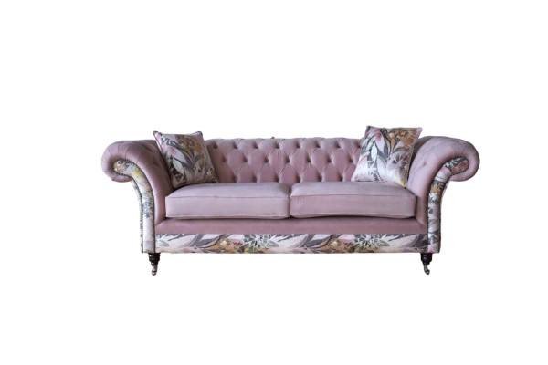 Een levendige driezitsbank van Chesterfield met een delicaat roze bloemenpatroon.