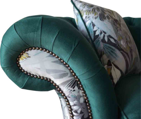 Een levendige driezitsbank van Chesterfield in een delicate smaragdkleur met bloemmotief.