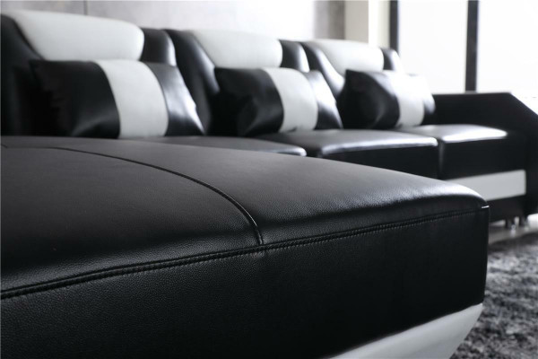 Ontspannen L-vormige bank in vorm van bankstel met verlichte woonkamer.