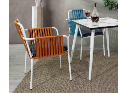 Originele stoelen in een lichte oranje kleur op witte poten van roestvrij staal met een zacht kussen.