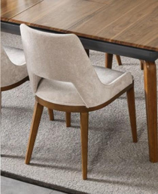 Een laconieke, moderne stoel met hoge poten van hout en bekleding in een prettige, lichte crèmekleur voor de eetkamer.