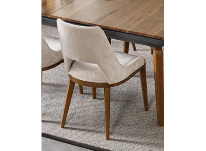 Een laconieke, moderne stoel met hoge poten van hout en bekleding in een prettige, lichte crèmekleur voor de eetkamer.