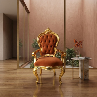 Elegante barokstoel in originele oranje kleur met glanzende gouden steunen.