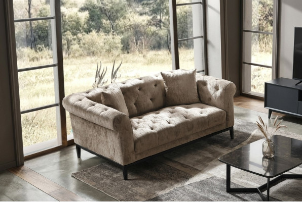 Gezellige beige Chesterfield driezitsbank voor in de woonkamer.