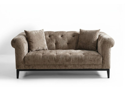 Gezellige beige Chesterfield driezitsbank voor in de woonkamer.
