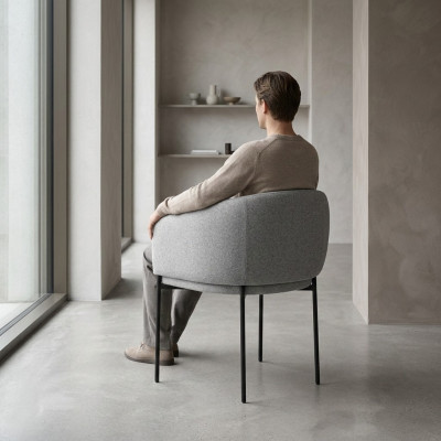 Grijze gestoffeerde stoel met armleuningen, ontwerper fauteuil voor één persoon in de woonkamer.