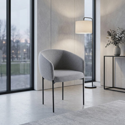 Grijze gestoffeerde stoel met armleuningen, ontwerper fauteuil voor één persoon in de woonkamer.